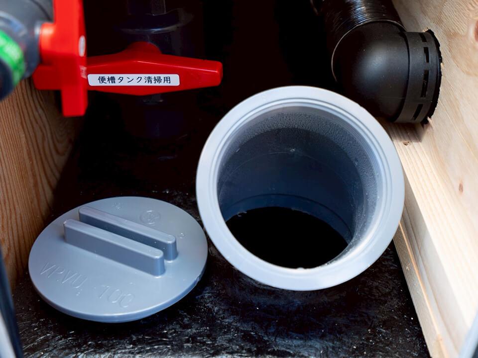 「便槽タンク清掃用」と書かれた赤いバルブと排水口